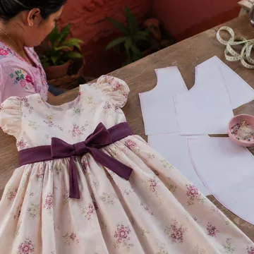 IMAGEN: pieza 6 de 13 del marquee — vestido infantil terminada junto a su molde impreso, miniatura cuadrada